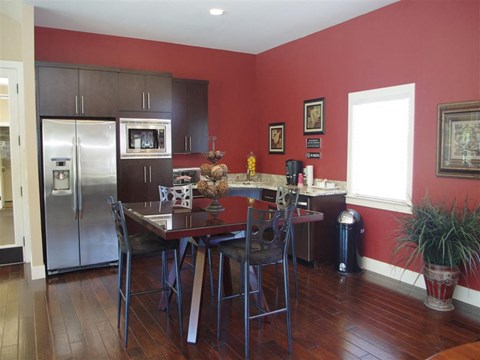 a kitchen with a dining table and a stainless steel refrigerator