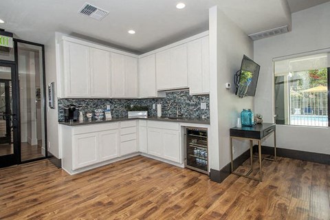 a kitchen with white cabinets and a wooden floor