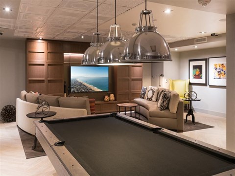 a living room with a pool table and a tv