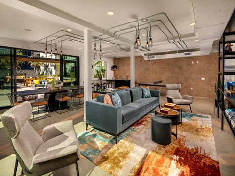 a living room with a couch and chairs and a bar