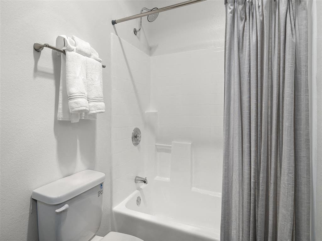 a bathroom with a toilet a bathtub and a shower curtain at Enclave, California, 90723