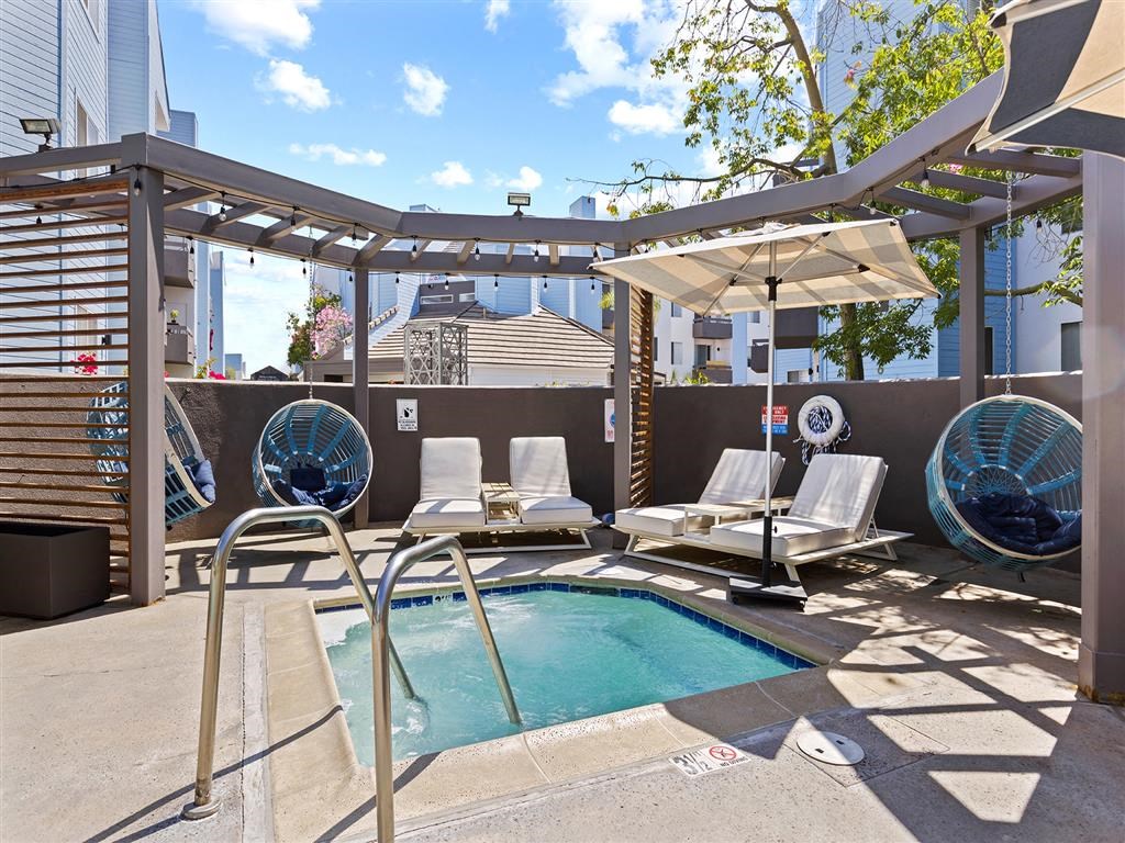 a pool with lounge chairs and a pergola at Enclave, Paramount, 90723
