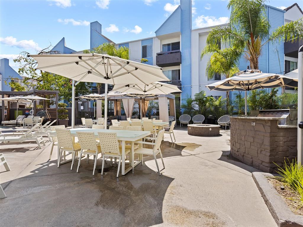 a patio with tables and chairs and umbrellas at Enclave, Paramount