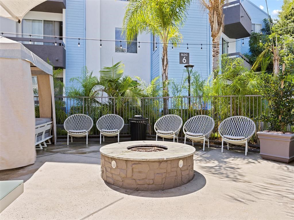 a group of chairs sitting around a fire pit in front of a building at Enclave, California, 90723