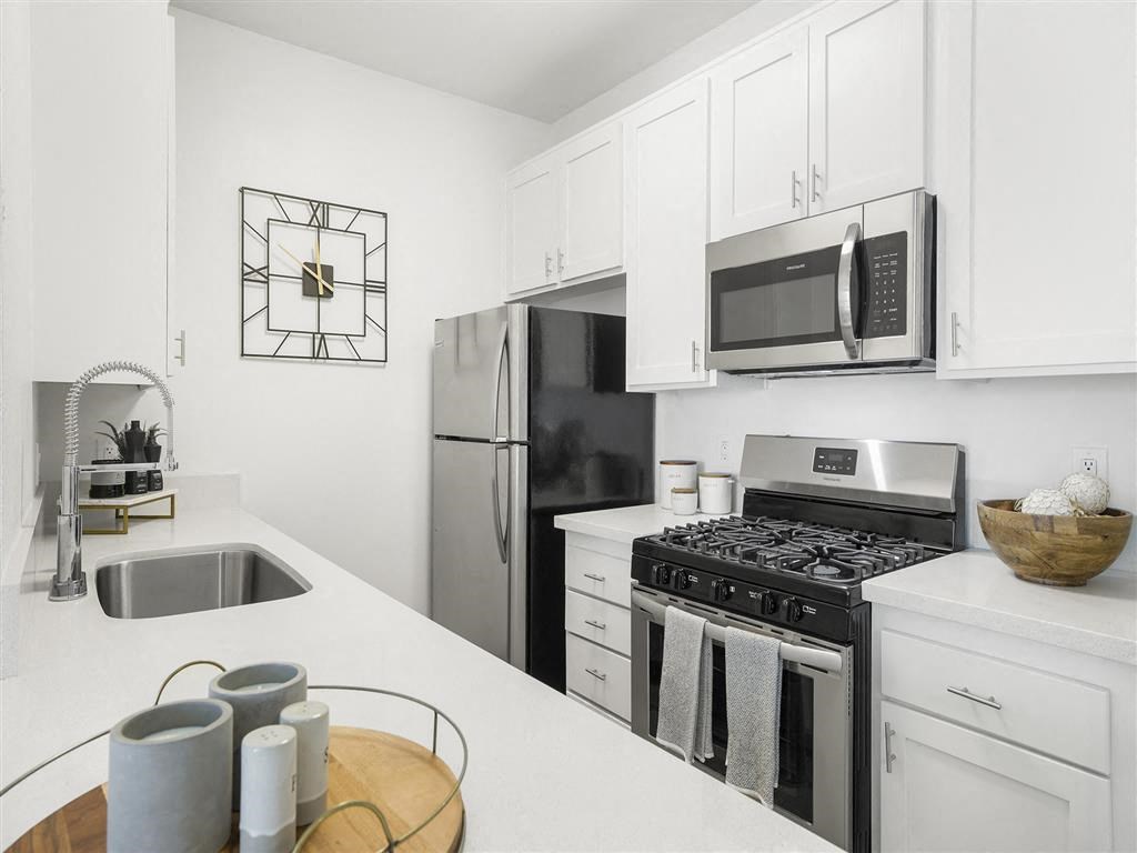 a kitchen with a stove top oven next to a sink at Enclave, California