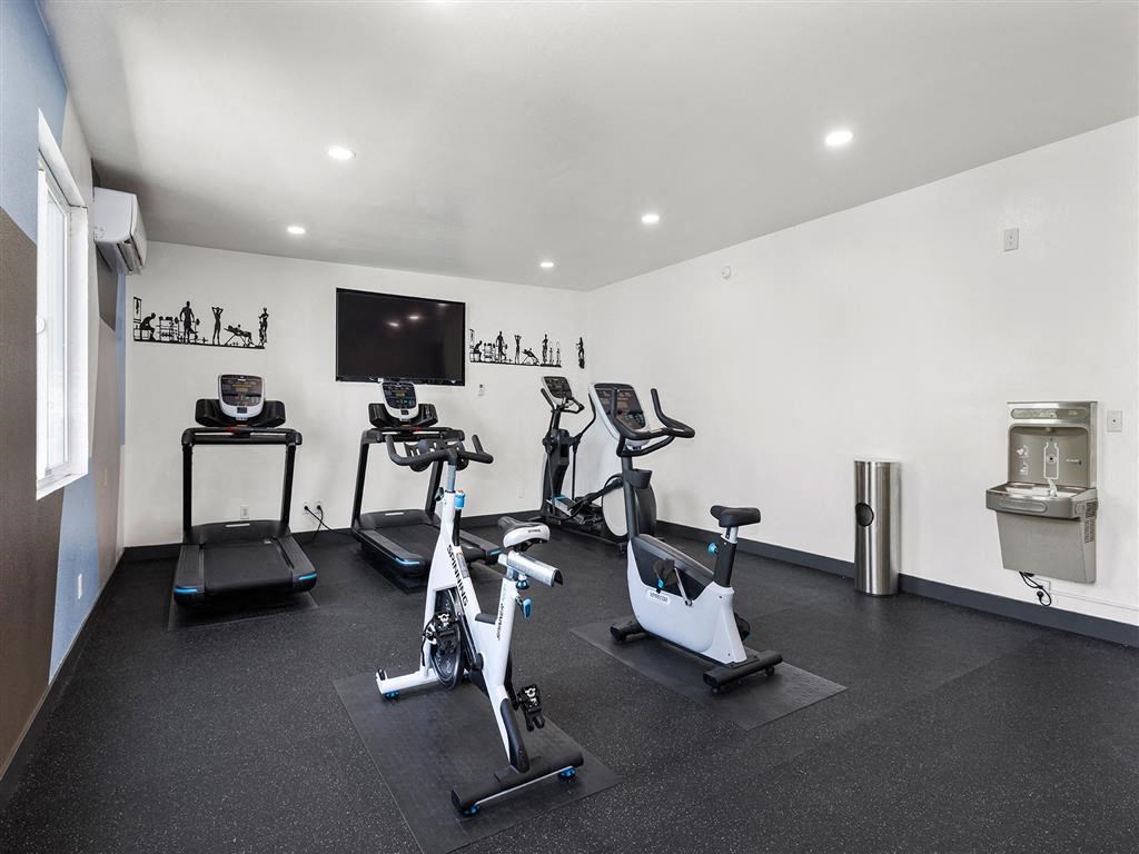 a room with a lot of exercise equipment and a tv on the wall at Enclave, Paramount, 90723