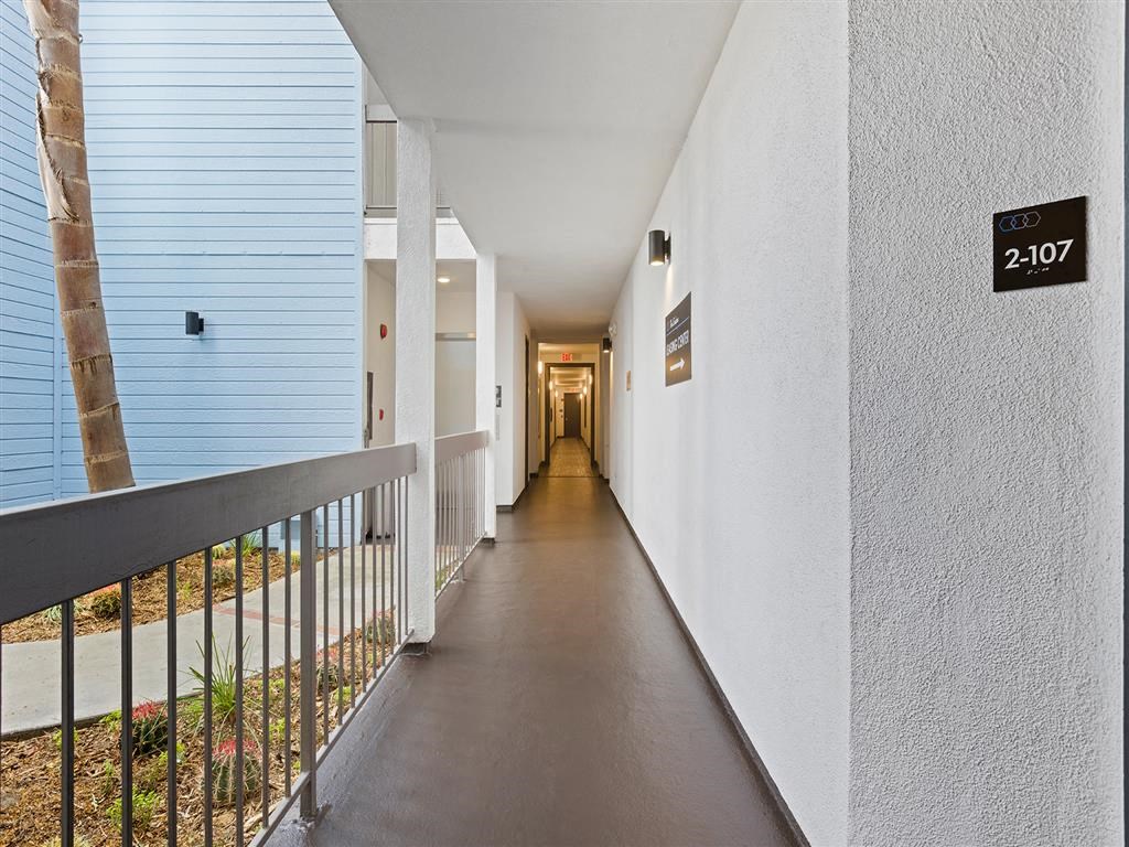 a hallway with a railing and a tree in the distance at Enclave, California