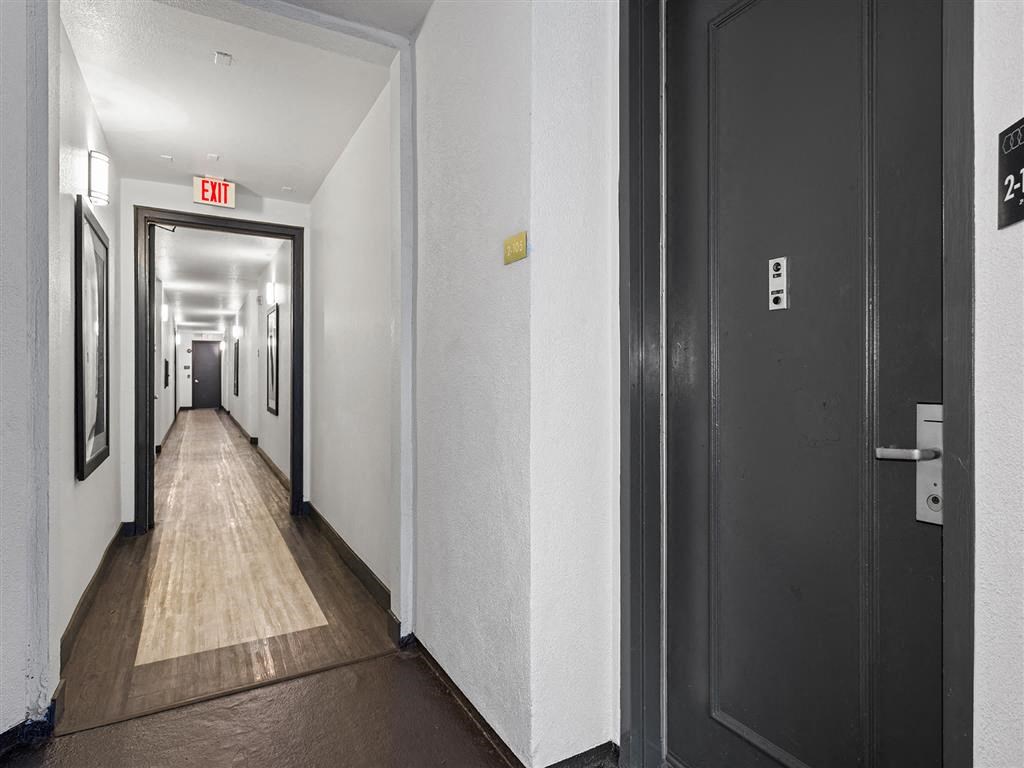 a hallway with black doors and white walls  at Enclave, Paramount, CA 90723