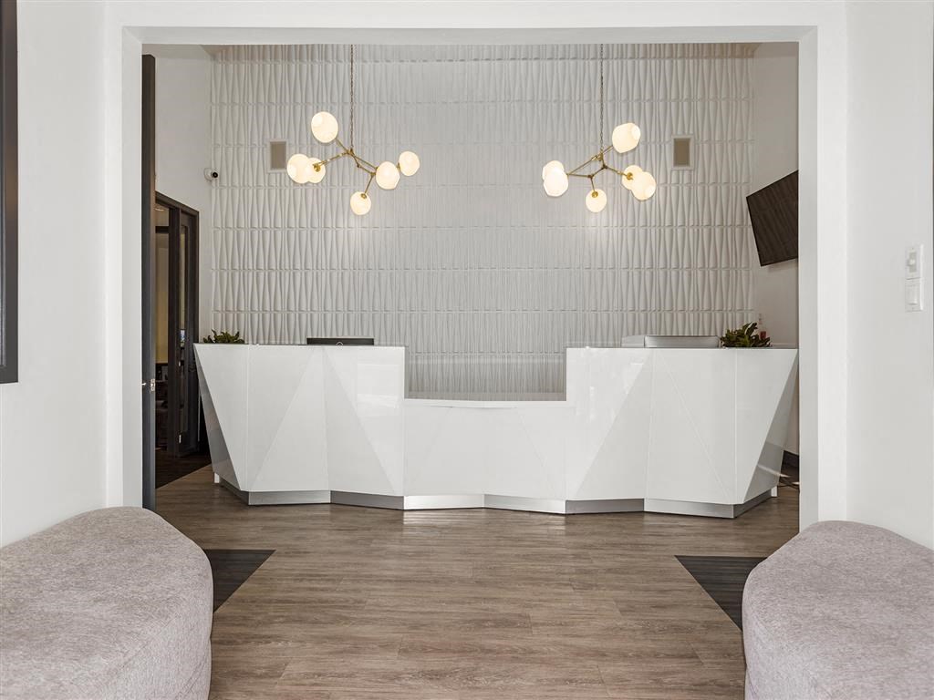 a white reception desk sitting on top of a hard wood floor at Enclave, Paramount, CA