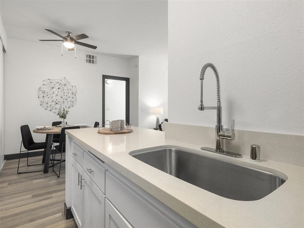 a kitchen with a sink and a ceiling fan at Enclave, Paramount, 90723