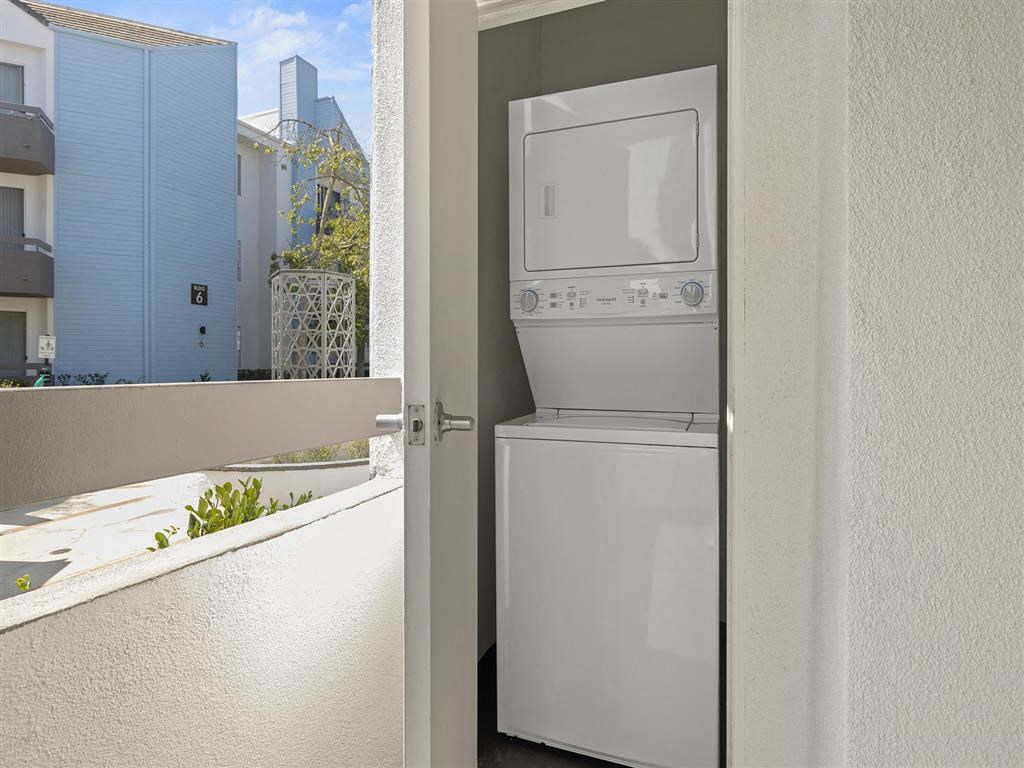 a white refrigerator freezer sitting next to a window at Enclave, Paramount, CA 90723