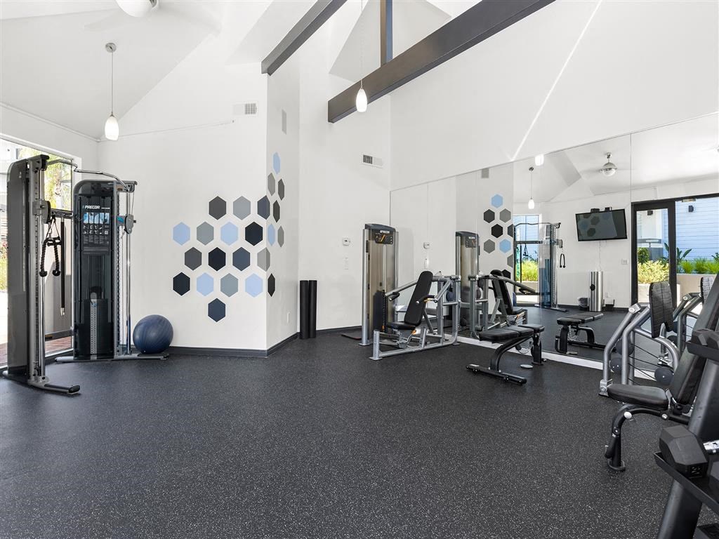 a gym with white walls and black flooring at Enclave, California
