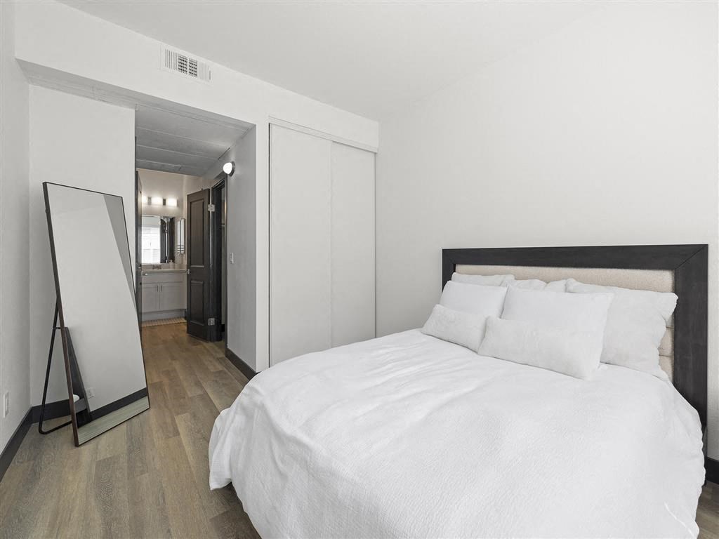 a bedroom with a large bed and a mirror at Enclave, Paramount, CA 90723