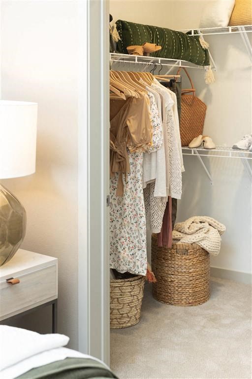 a closet filled with clothes and baskets in a bedroom