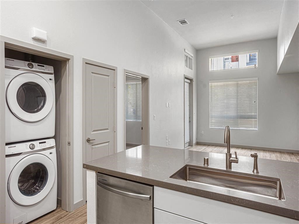 a white laundry room with a counter and washes and a dryer