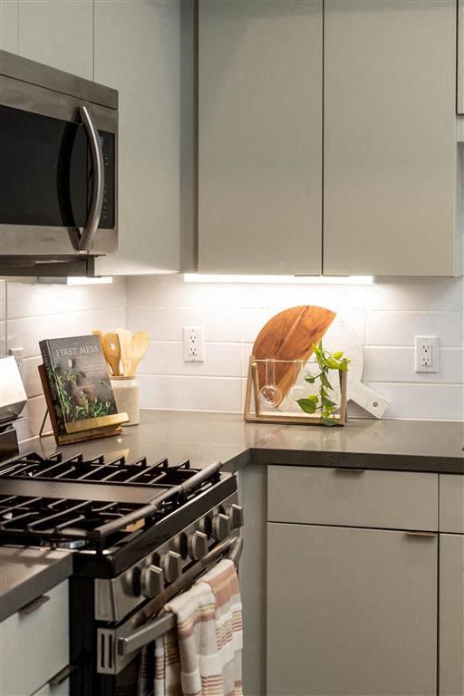 a white kitchen with a stove and a microwave