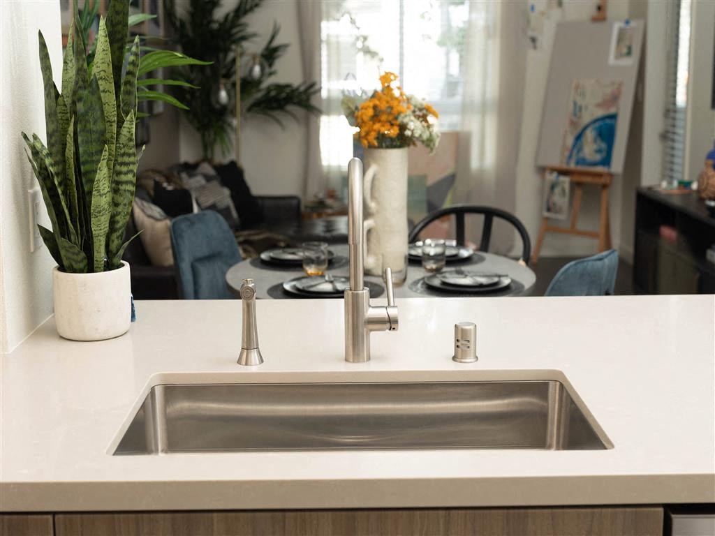 a kitchen counter with a sink and a dining room table