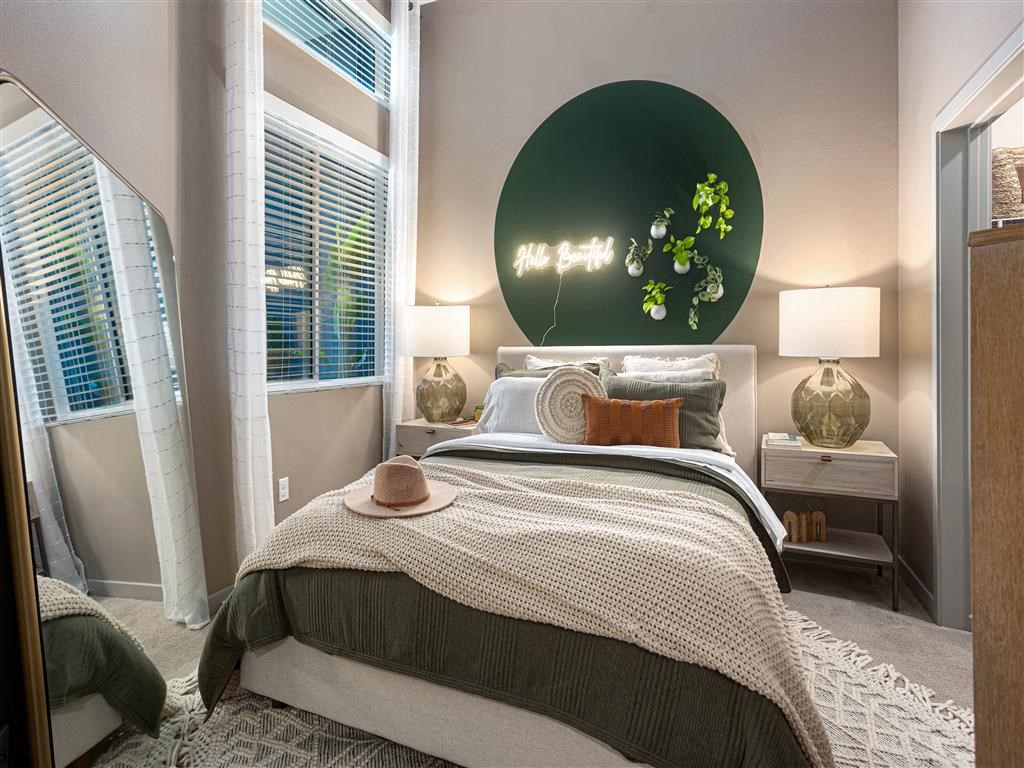 a bedroom with a bed and a green painting on the wall