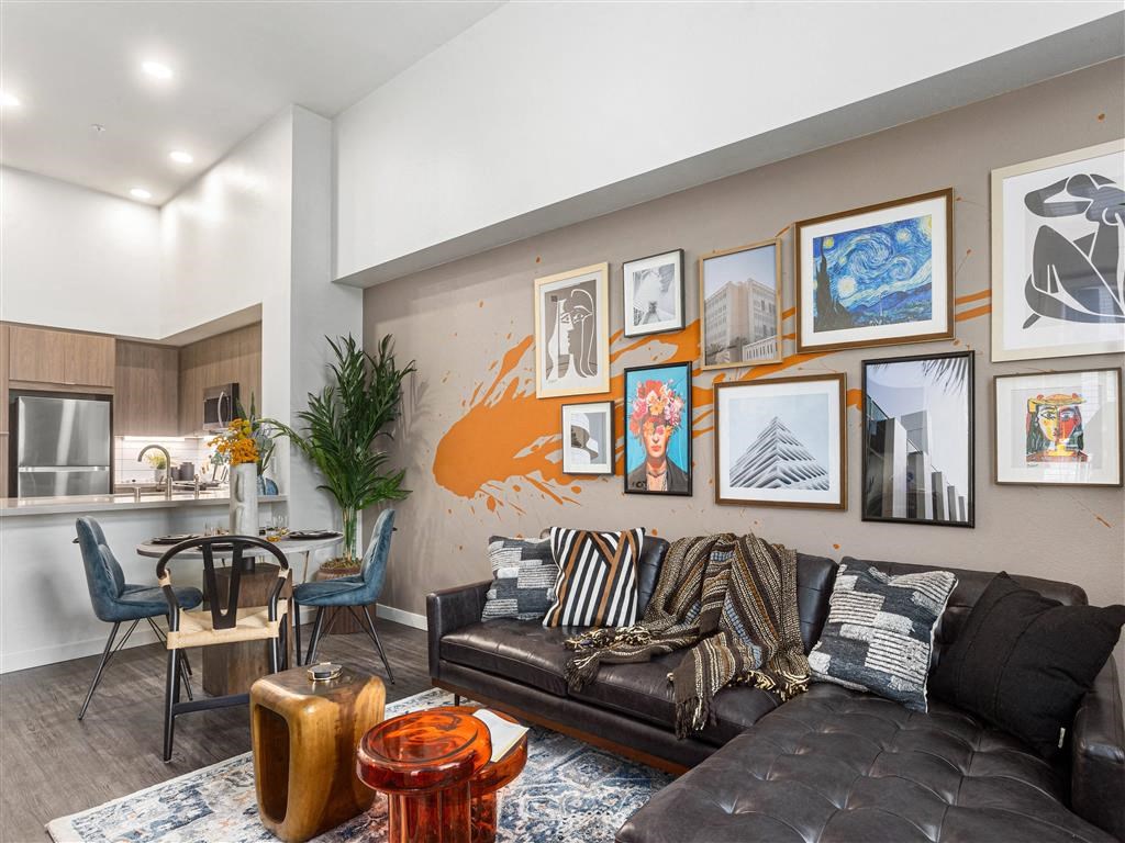 a living room with a leather couch and a wall full of pictures