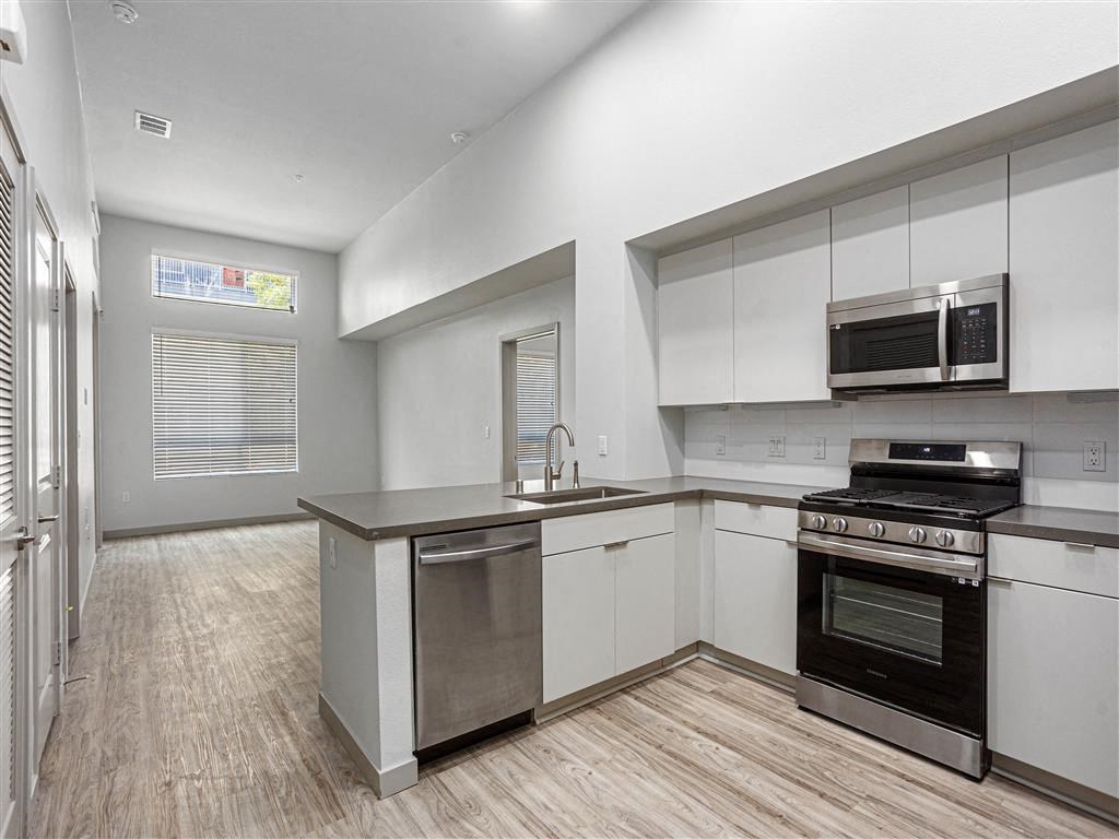 a kitchen with stainless steel appliances and a wood floor