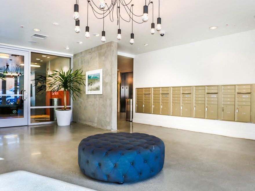 a locker room in a gym with lockers and a blue ottoman