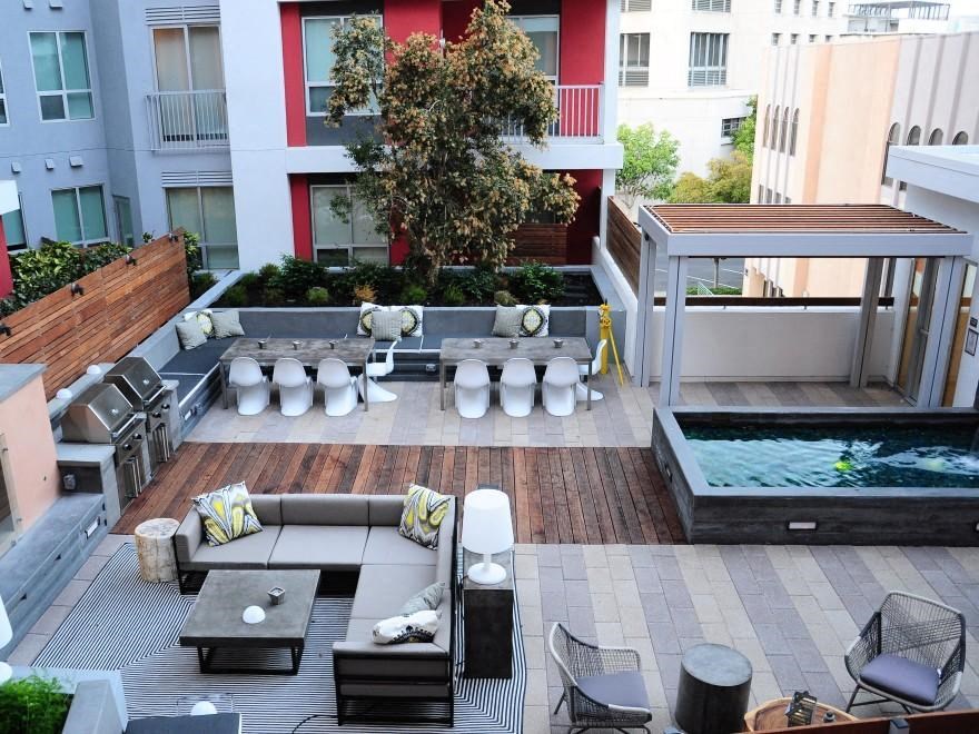 a communal area with a pool and furniture in a courtyard