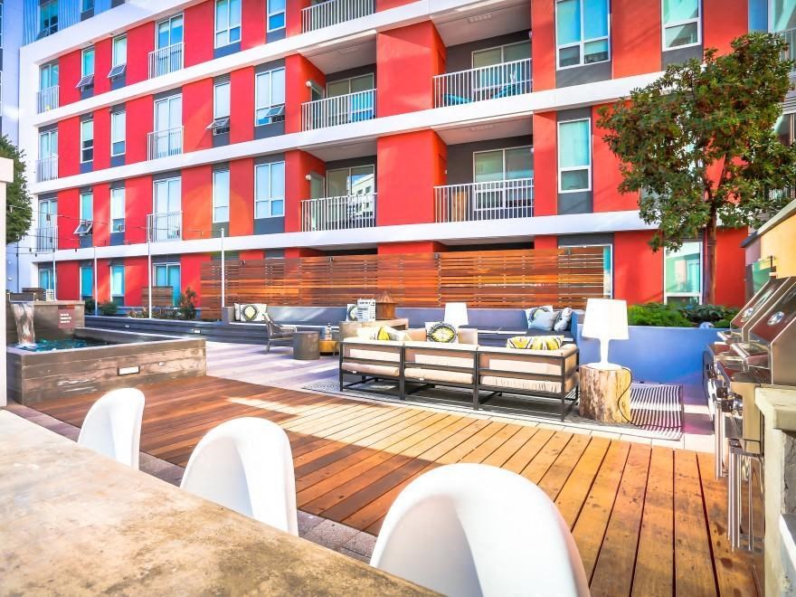 a patio with a table and chairs in front of a building