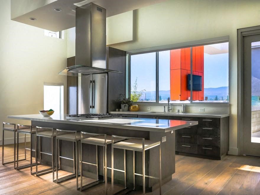 a kitchen with an island and a stove and a large window