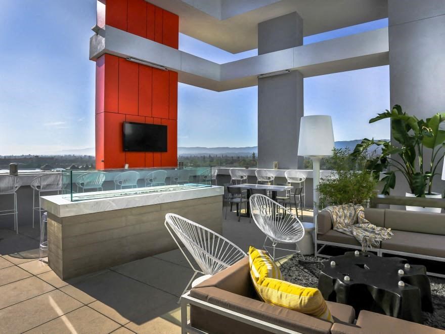 a living room with a jacuzzi and a large window overlooking the city