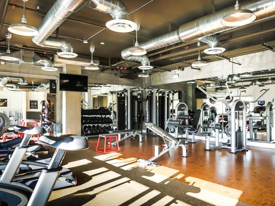 a gym with weights and other exercise equipment on a wooden floor
