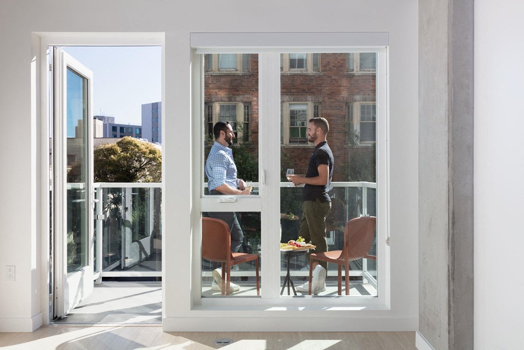 two men sitting at a table in a window
