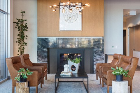 a living room with leather chairs and a fireplace