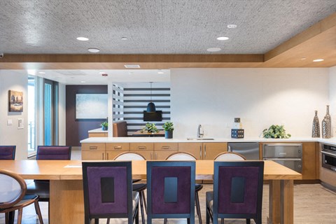 a kitchen and dining room with purple chairs and a table