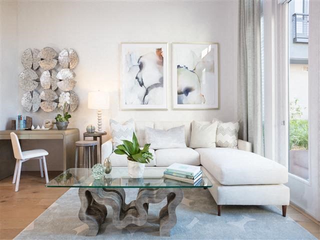 a living room with a white couch and a glass table