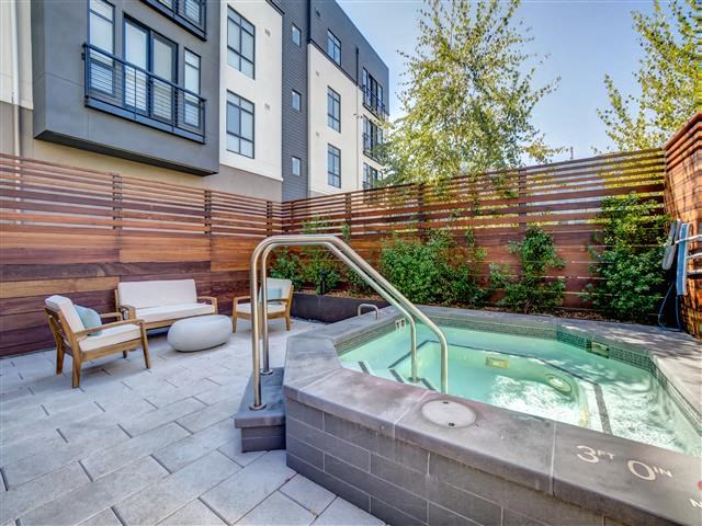 a hot tub on a patio next to a building