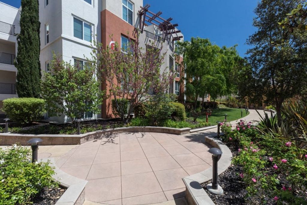 walkway outside apartment building surrounded by greenery