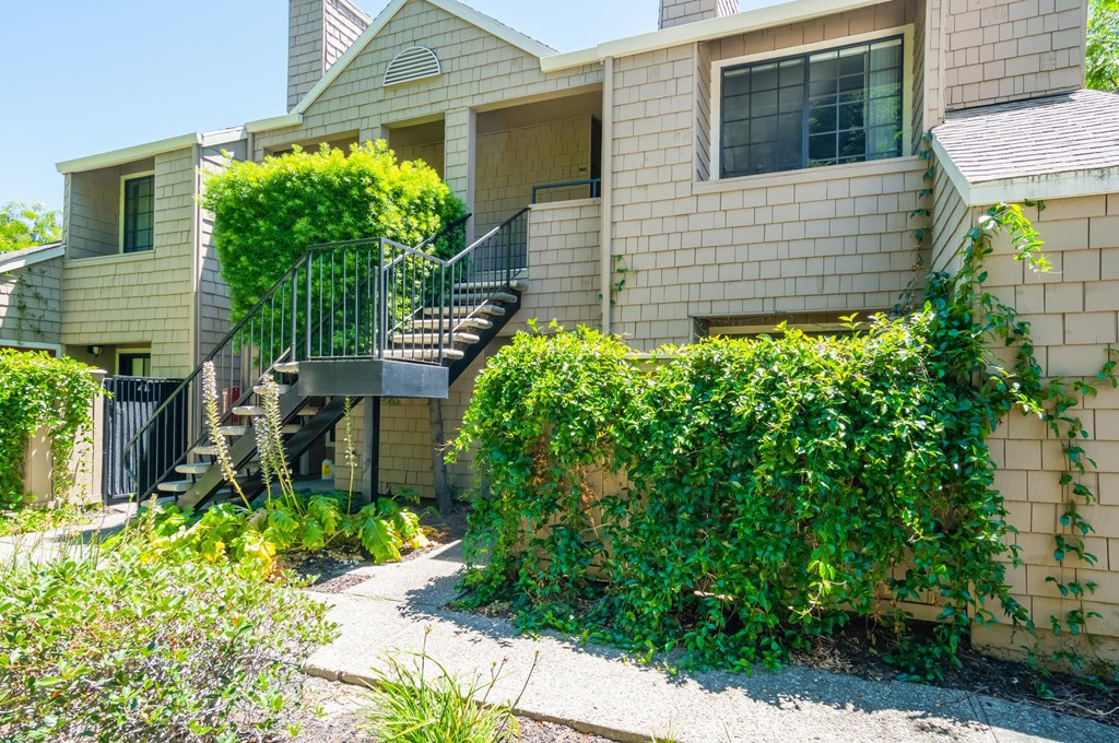 a house with stairs and a sidewalk in front of it