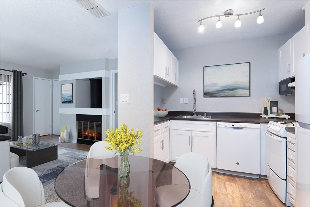 a living room with a table and a kitchen with a fireplace