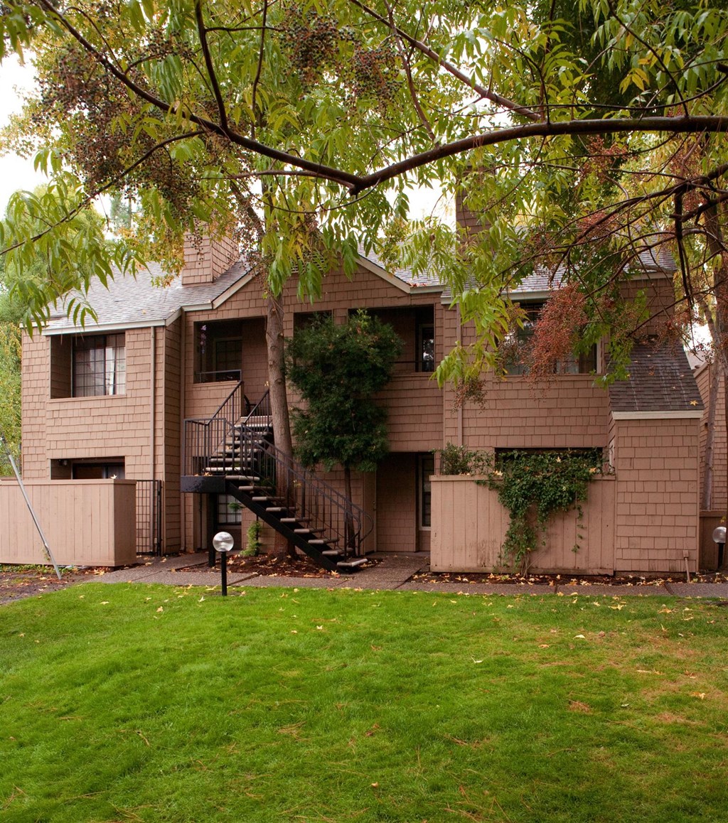 an apartment building with a yard in front of it