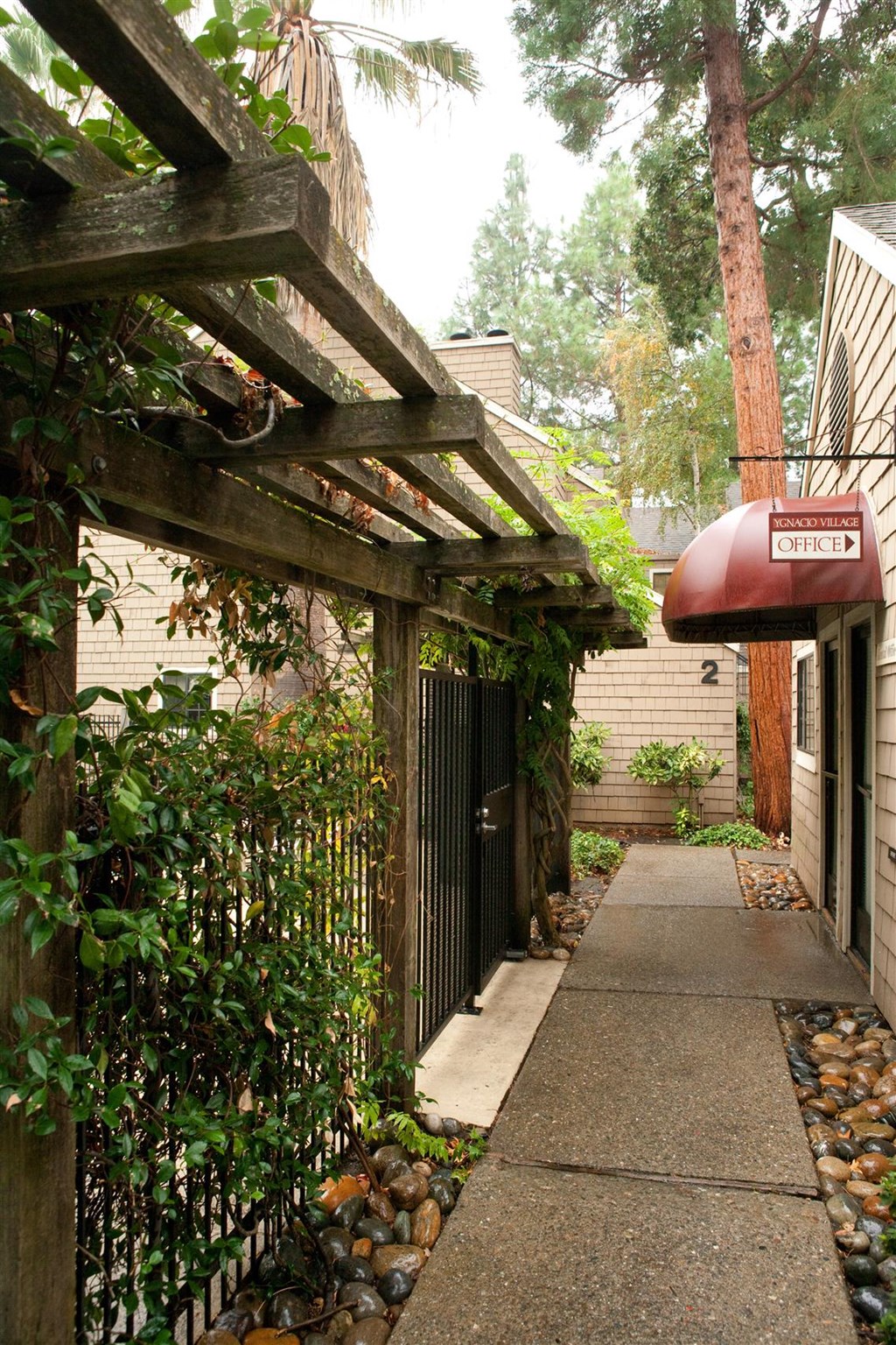 a walkway with a pergola in front of a house