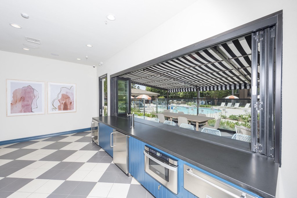 a kitchen with a counter and a window overlooking a pool