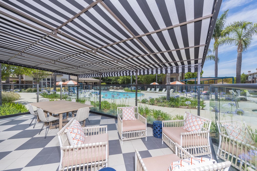 a patio with tables and chairs and a swimming pool
