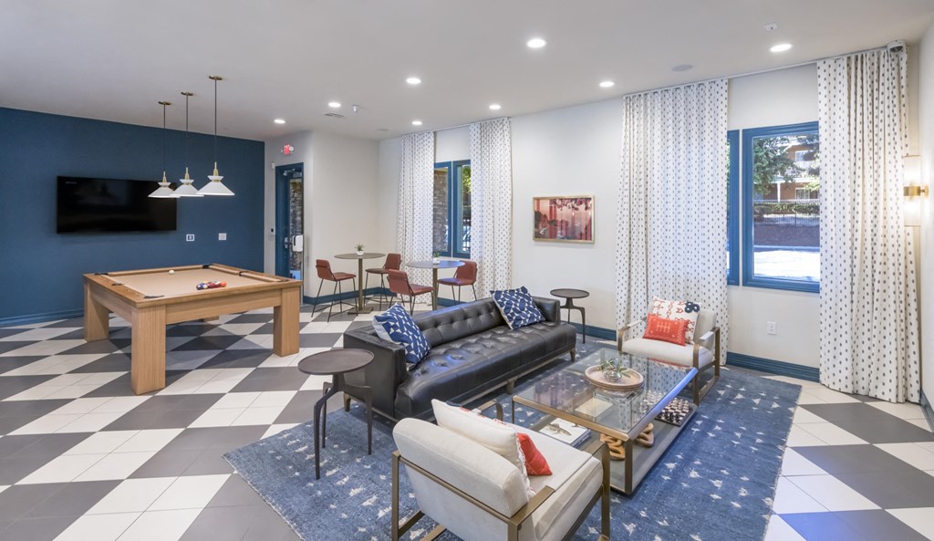 a living room with couches and a table with a pool table