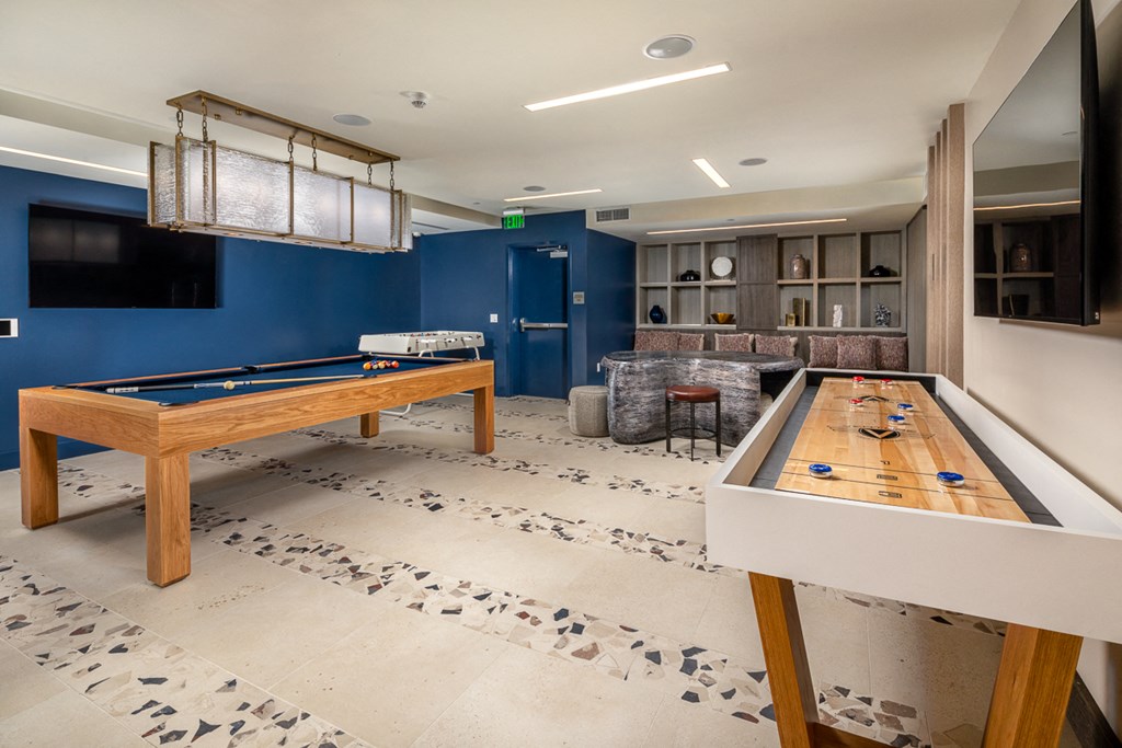 a game room with two pool tables and a television