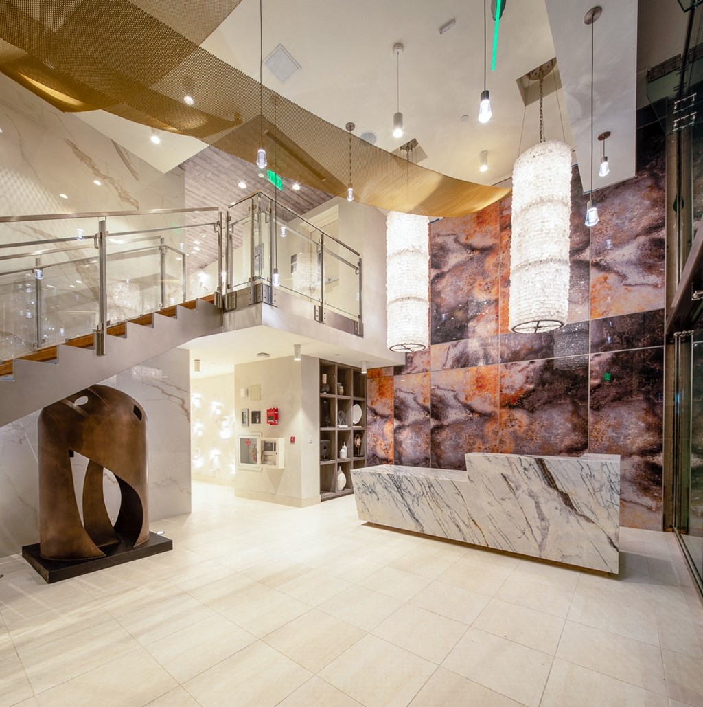 a lobby with a marble wall and a staircase