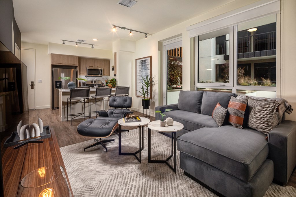 an open living room and kitchen with a couch and a chair