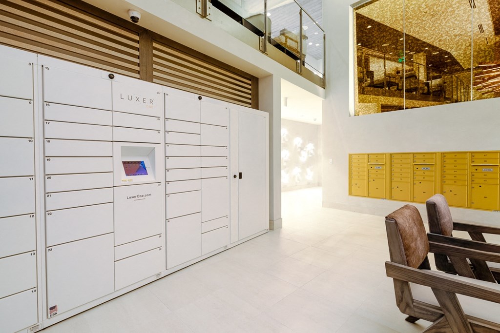 the lockers in the lobby of a building with wooden chairs