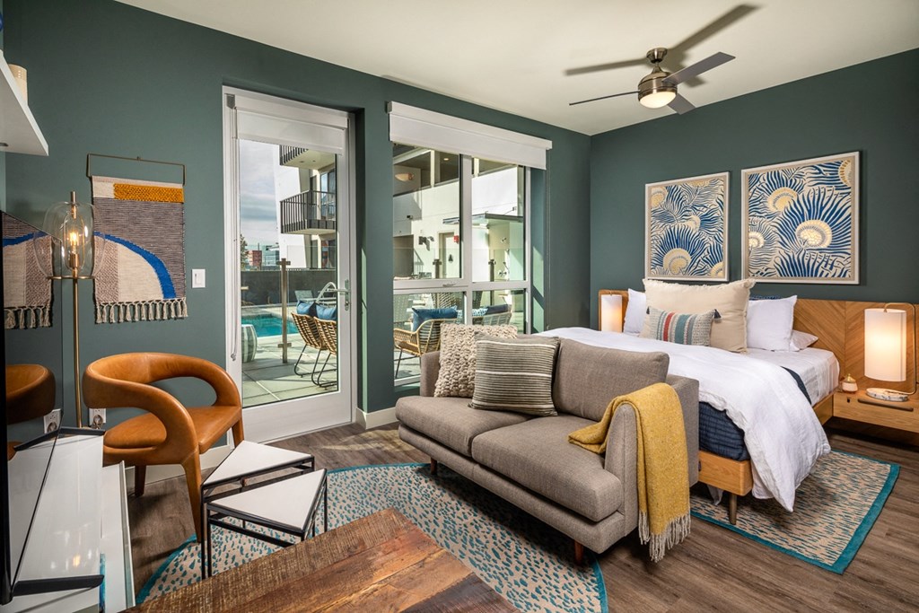 a bedroom with a bed and a couch and sliding glass doors