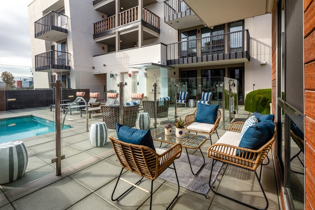 a patio with chairs and tables and a pool