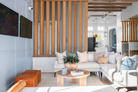 A living room with a white couch and a wooden slat wall.